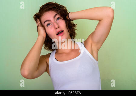 Studio shot della bella ragazza adolescente pensare con entrambe le mani o Foto Stock