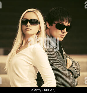 Felice moda giovane uomo e donna che indossa gli occhiali da sole in una strada di città Foto Stock
