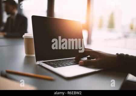 Imprenditore lavora in ufficio con un computer portatile. Concetto di condivisione internet Foto Stock