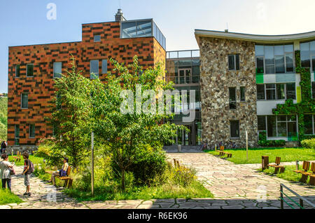 Dilijan,Armenia,agosto 24,2018:Vista dal giardino al corridoio vetrato collegando le attività amministrative e di edifici educativi dell'internation Foto Stock