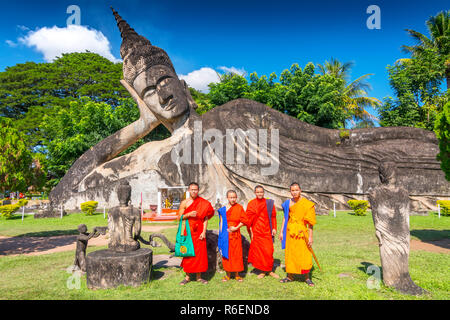 I monaci con il Buddha reclinato a Xieng Khuan Buddha Park Vientiane Laos Foto Stock