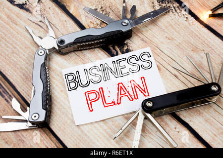 Mano concettuale di scrittura di testo Didascalia ispirazione mostra Business Plan pianificazione. Il concetto di business per la preparazione della strategia del progetto scritto su una nota adesiva sullo sfondo di legno con coltello da tasca Foto Stock