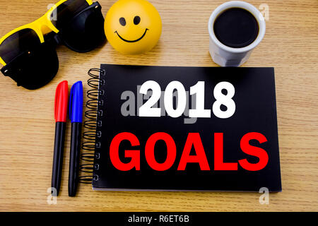 Conceptual la scrittura a mano didascalia di testo che mostra il 2018 Obiettivi. Il concetto di business per la pianificazione finanziaria, la strategia aziendale scritto su una nota adesiva con spazio sul legno vecchio sfondo di legno con occhiali da sole Foto Stock