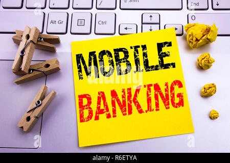La scrittura a mano didascalia di testo ispirazione mostra Mobile Banking. Il concetto di Business di Internet Banking e-bank scritto su una nota adesiva sulla carta il bianco sullo sfondo della tastiera. Foto Stock