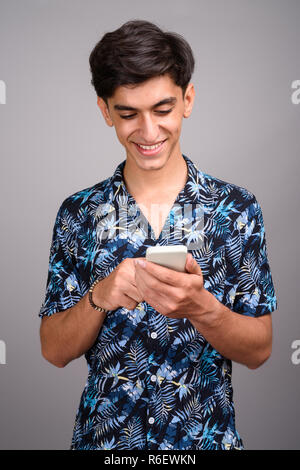Giovani persiano bello ragazzo adolescente utilizzando il telefono cellulare Foto Stock