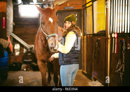 Pilota femmina addestra il cavallo fuori del maneggio Foto Stock