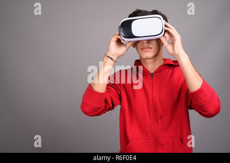 Il persiano ragazzo adolescente utilizzando occhiali VR per realtà virtuale Foto Stock