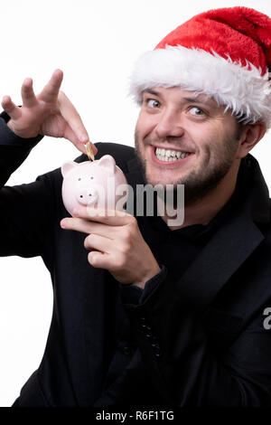 Immagine di uomo felice in santa hat con maiale giocattolo Foto Stock