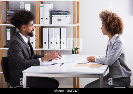 Due imprenditori aventi la conversazione in ufficio Foto Stock