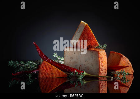 Pecorino rosso pecorino con il timo e il pepe rosso. Tradizionale formaggio di pecora con spises prodotta nel sud dell'Italia. Foto Stock