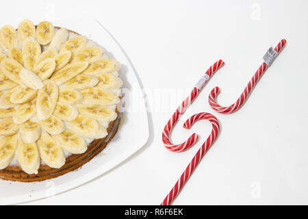 Banana torta biscotto su uno sfondo bianco. Torta dolce con latte condensato salsa. Prodotti da forno Foto Stock