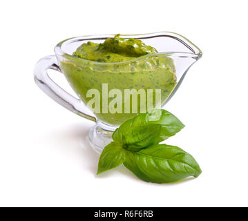 Il Pesto in salsa di vetro la barca con una foglia di basilico. Isolato. Foto Stock