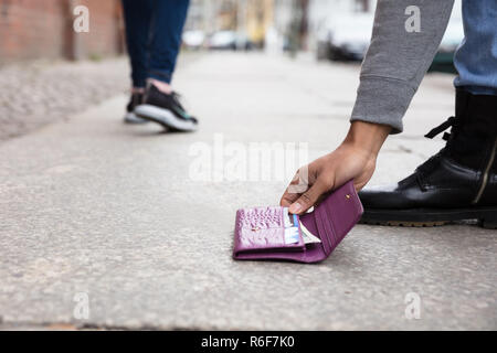 Persona di prelevare perso in borsa Foto Stock