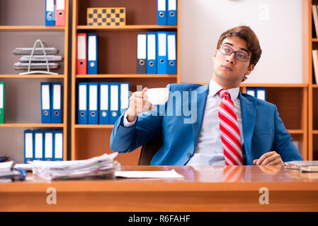 Giovane uomo politico bello seduto in ufficio Foto Stock