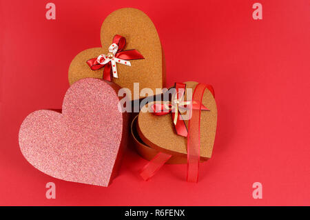 Rosso e oro regali di San Valentino su una carta di colore rosso sfondo. Foto Stock