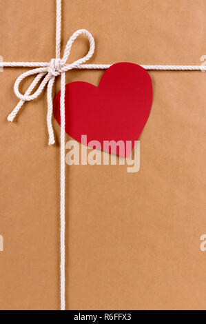 Regalo di San Valentino con tag regalo, marrone confezione di carta pacco sfondo, spazio copia, verticale Foto Stock