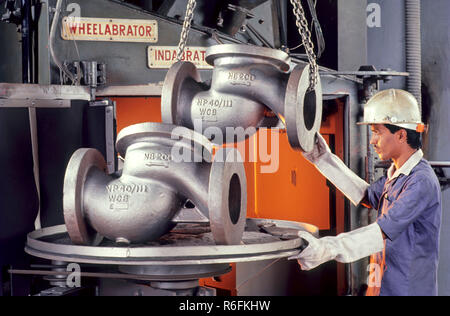 uomo che indossa il casco di sicurezza che lavora in fabbrica di valvole Foto Stock