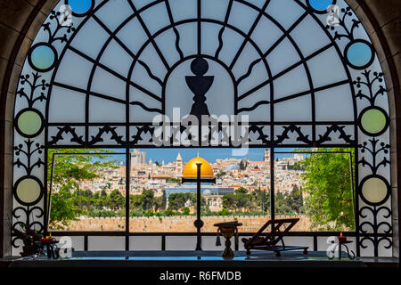 La Città Vecchia di Gerusalemme e la Cupola della roccia, visto con la silhouette di una croce nella finestra del Dominus Flevit Cappella, Gerusalemme, Israele, metà Foto Stock