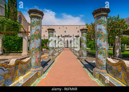 Sunny chiostro delle Clarisse decorate con piastrelle di maiolica dal monastero di Santa Chiara a Napoli, Italia Foto Stock