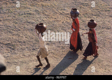 Due donne e un bambino che trasportano acqua potabile vicino a Jodhpur in Rajasthan, India, Asia, asiatico, indiano Foto Stock