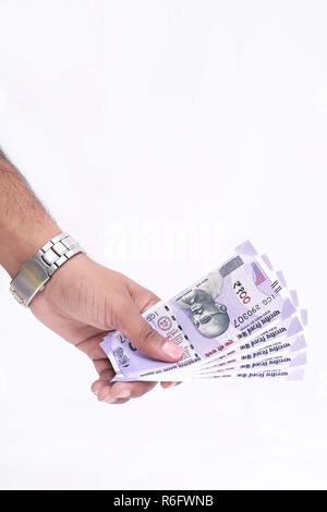 Indian un centinaio di rupee note in mano. Isolato su uno sfondo bianco. Foto Stock