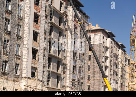 Macchina di sollevamento sullo sfondo dell'edificio in costruzione Foto Stock