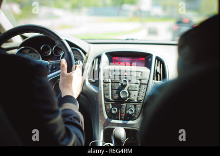 Giovane uomo barbuto alla guida di una vettura, cabina interna giostre, guardando road, guida, trattenendo il volante. Foto Stock