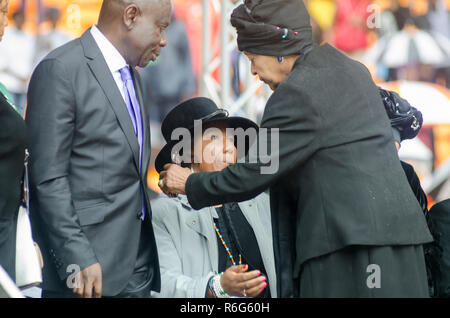 Winnie Mandela abbraccia Nelson Mandela della figlia Maki (Makiziwe) Mandela come arriva il memoriale pubblico servizio per ex Presidente Nelson Mandela (Madiba) alla FNB Stadium, a Soweto, Sud Africa, martedì 10 dicembre 2013. Makiziwe è figlia di Madiba prima moglie Evelyn Mase. Foto: EVA-sacco JANSSON Foto Stock