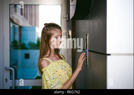 La donna compone un codice appartamento su un sistema elettronico di pannello doorphone Foto Stock