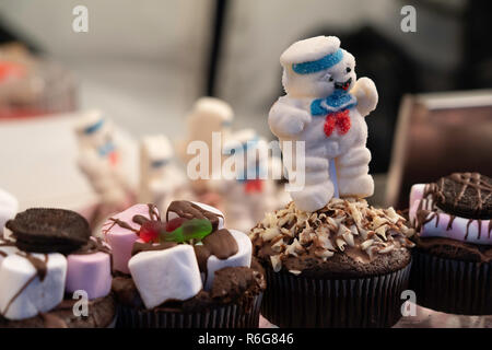 Appetitoso cupcake al cioccolato con zuccherato Snowman in cima ad un mercatino di Natale in Harrogate, North Yorkshire, Inghilterra, Regno Unito. Foto Stock