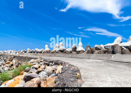 Struttura di frangionde con road e blocchi di cemento sotto il cielo nuvoloso. Background Industriale foto Foto Stock