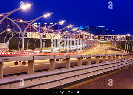 Saint Petersburg, Russia - 24 agosto 2018: autostrada illuminata di San Pietroburgo con close up della barriera di sicurezza stradale e l'illuminazione di una strada di notte. Foto Stock