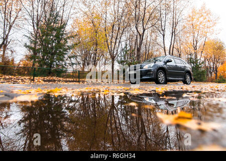 Nero SUV giapponesi sulla strada d'autunno in giorno di pioggia Foto Stock