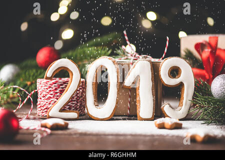 Felice Anno Nuovo 2019 saluto fatta con pan di zenzero i cookie, le luci di Natale e di neve artificiale Foto Stock