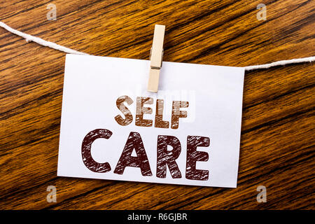 Annuncio della scrittura testo che mostra Self Care. Il concetto di business per prendere la cura per la propria salute scritto su una nota adesiva carta sullo sfondo di legno. Foto Stock