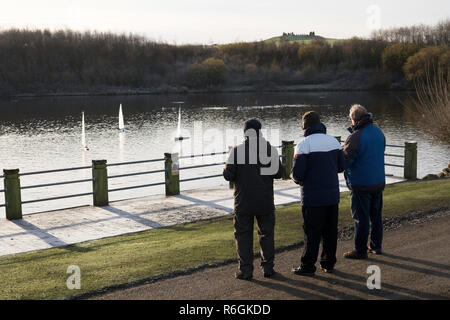 Gli uomini del modello di Vela Yacht in Herrington Country Park su un gelido giorno, Sunderland, England, Regno Unito Foto Stock