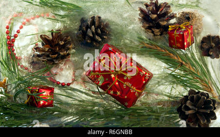 Sfondo rosso di perle e craft regalo di Natale , cono, ramoscello di pino in cubetti di ghiaccio con bolle di aria.Felice anno nuovo 2019 greeting card . Co Foto Stock