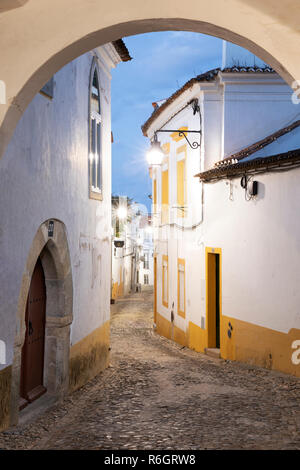 Strette in ciottoli street nella città vecchia con le sue case dipinte di bianco all'alba, Evora, Alentejo, Portogallo, Europa Foto Stock