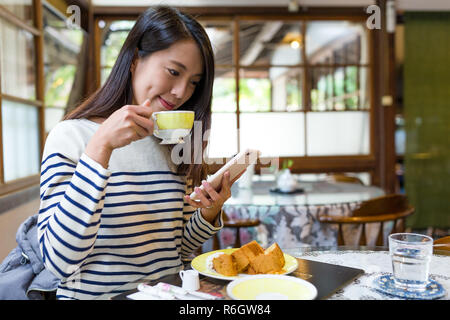 Donna di gustare la colazione in caffetteria Foto Stock