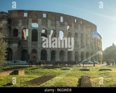 Il Colosseo a Roma, Lazio, Italia. Cavalli con carrozze attendono di portare i turisti in un tour della città. Foto Stock