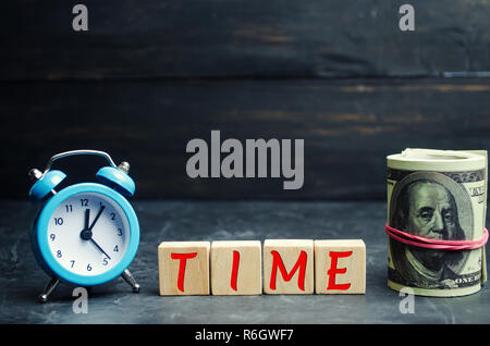 Orologio blu, la scritta 'tempo' e denaro su uno sfondo nero. Il concetto di 'tempo - denaro." La gestione del tempo. Risparmio di denaro Foto Stock