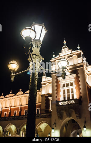 Notte vecchia area commerciale di Cracovia nelle luci dei lampioni. Foto Stock