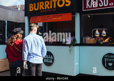 Londra/UK - 25 Marzo 2018: turisti la scelta di cibo sulle bancarelle del mercato di Camden a Londra, Regno Unito Foto Stock