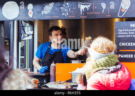 Londra/UK - 25 Marzo 2018: buing turistica greca gyros nel mercato in stallo il mercato di Camden a Londra, Regno Unito Foto Stock