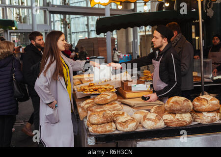 Londra/UK - 25 Marzo 2018: donna pane di acquisto sul mercato di Camden a Londra, Regno Unito Foto Stock