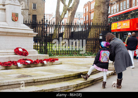 London, Regno Unito - 11 Marzo 2018: la mamma e figlia guardando il Kensington Memoriale di guerra sulla intersezione di Kensington Church Street e Kensington Hi Foto Stock