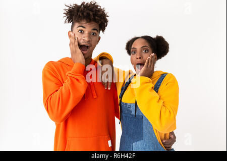 Immagine di sorpresa americano africano giovane in abiti colorati chiedendo con open mouthes isolate su sfondo bianco Foto Stock