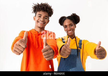 Immagine di allegro americano africano giovane in abiti colorati che mostra pollice in alto isolato su sfondo bianco Foto Stock