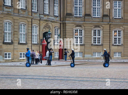 Segway piloti passando Royal vita delle guardie in servizio al di fuori del Palazzo Amalienborg, Copenhagen, Danimarca e Scandinavia Foto Stock