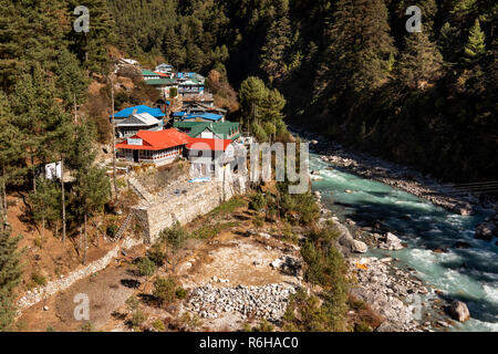 Il Nepal, Jorsale (Thumbug), Dudh Khosi fiume che fluisce oltre il villaggio Foto Stock